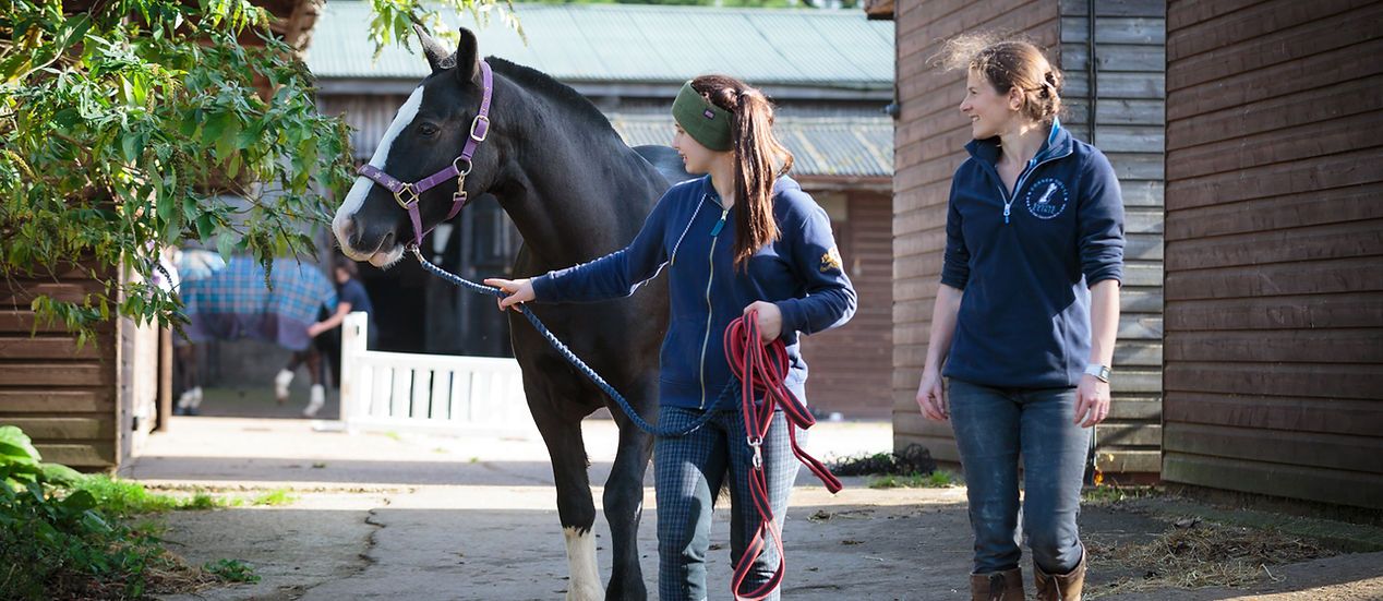 Volunteers leading a horse at Lowlands Farm RDA